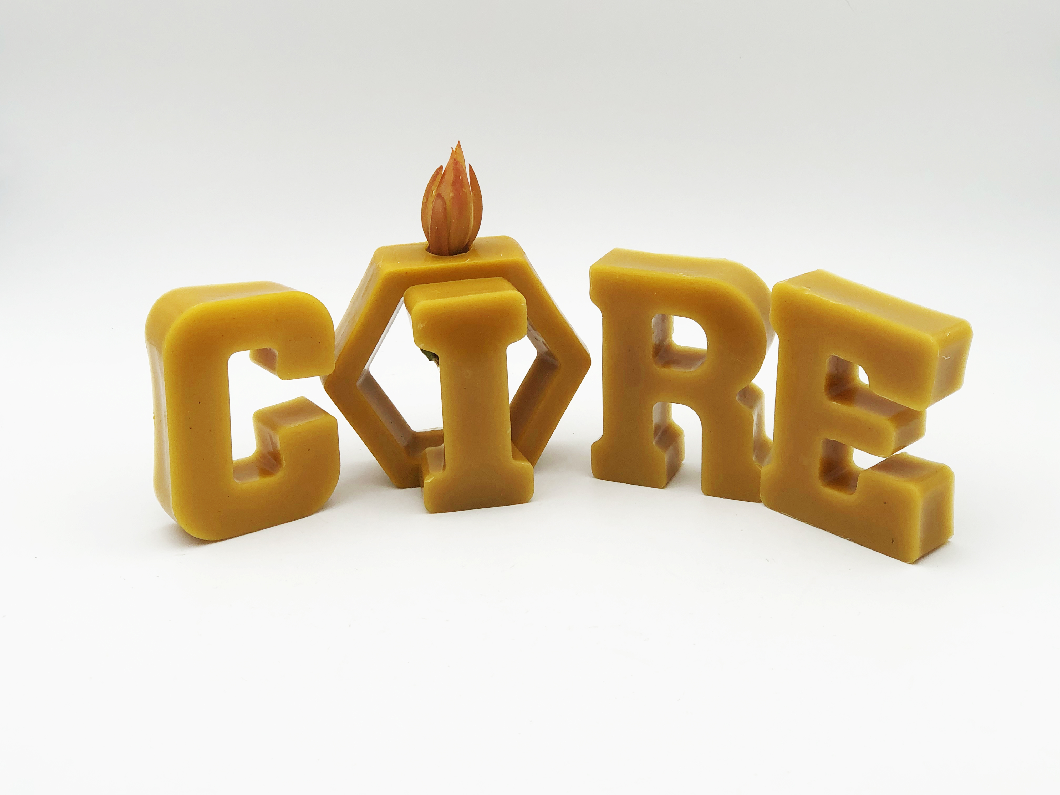 Image mot écrit en grosse lettre cire avec une flamme sur le i en fleurs en cire abeille pour cadeau ou décoration original