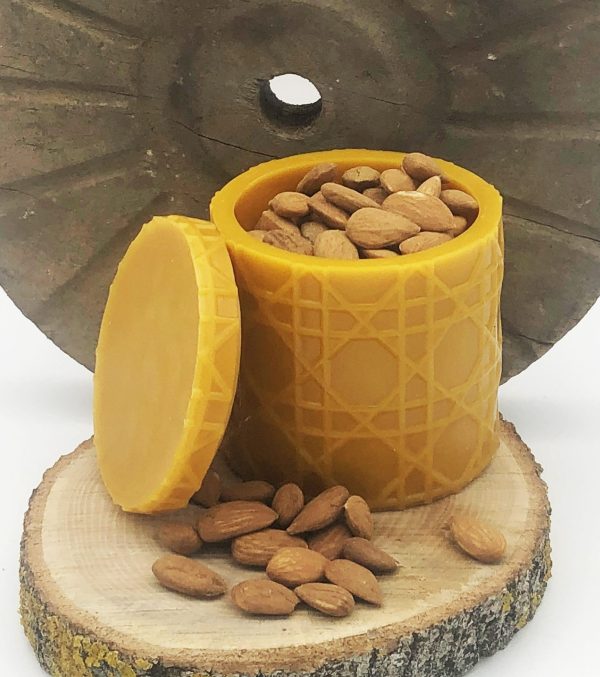 Image pot motif osier jaune naturel ouvert avec amende et roue en bois sur rondin de frêneen cire abeille pour cadeau original ou objet de décoration maison